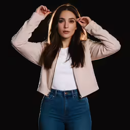 a girl with a white t - shirt and jeans, holding her hands to her ears