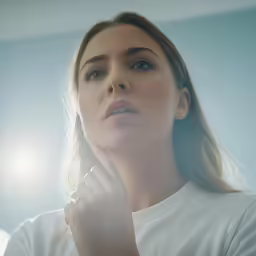 a woman holding her hand up to her face