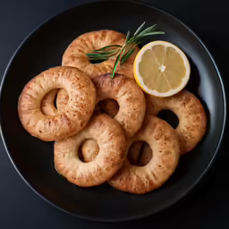some lemon slices and some bagels are on a plate