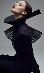 a woman posing in black clothes and holding her neck open