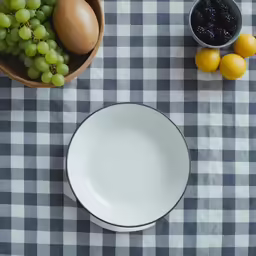 a bowl and fruit sitting on a table cloth