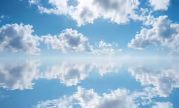 a large body of water with clouds in the background