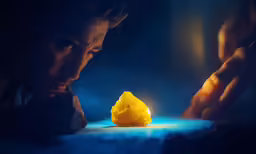a kid looking down at something yellow in front of him