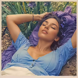 a woman with her head down laying in the grass
