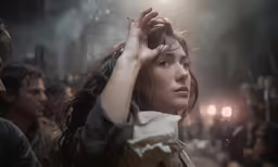 a woman holding her hand in the air in front of some other people