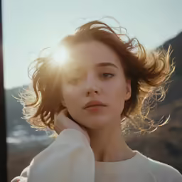 the young woman is wearing a sweater and holding her hair in her hand