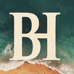 a big letter is standing up in front of an ocean