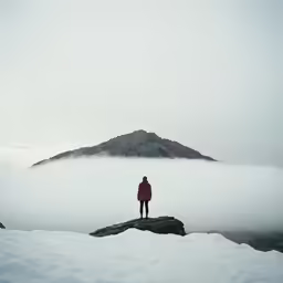 a man standing on a rock in the snow