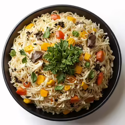 a bowl of noodles with vegetables and parsley