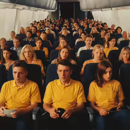 several people sit in rows on seats inside an airplane