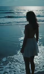 a woman standing in the shallow water of the ocean