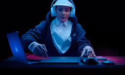 a woman wearing head scarves, a blue sweater and a headscarf uses a computer