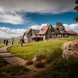 three people walk up a path in front of a large house