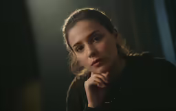 a woman with a thoughtful expression sitting