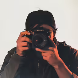 the man is holding up a camera and taking a selfie