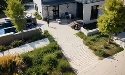 a large, elegant home has several landscaping features