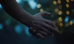 a close up of hands with lights in the background
