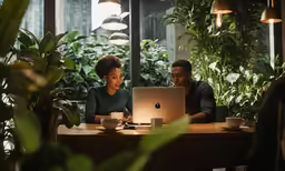 two people looking at an apple computer
