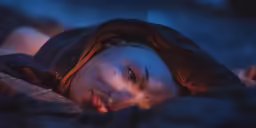 a man laying on a bed under the covers