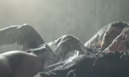 a woman laying in the rain with her arm around her head
