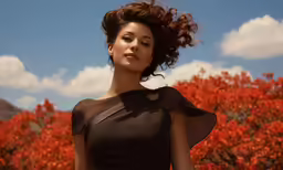 a woman in a black dress standing outside