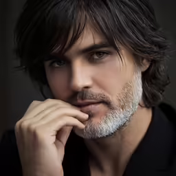 a man in black shirt and long hair posing for the camera