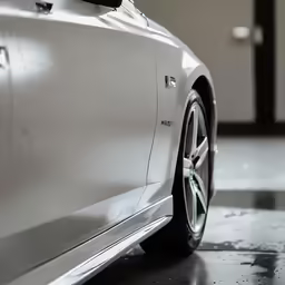 a white car parked inside of a garage