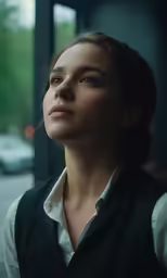 woman in black vest looking to the side
