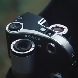 a black and silver camera being held up