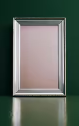 a silver frame sitting on a table next to green wall