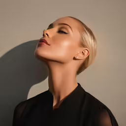 a woman in black shirt with her head turned to the side