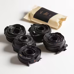 several black camera lenses sit on top of the same lens