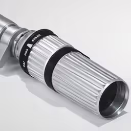 a metal object with a black top and white side