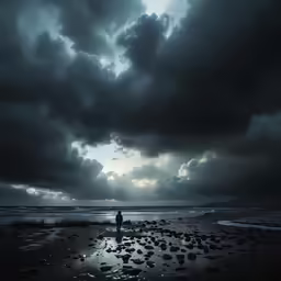 a lone person walks along the shore of a beach