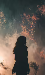 a woman standing against a sky that has fireworks