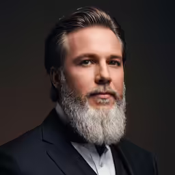a man with white beard wearing a suit and bow tie