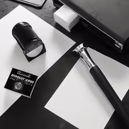 a pen and a camera sitting on a table