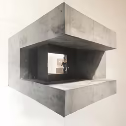 a man stands in an open window of concrete