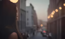 a woman looking down a city street at traffic