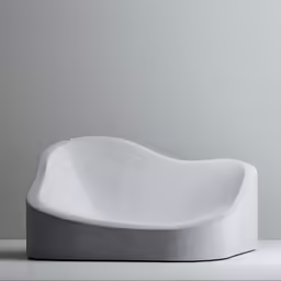 a large white, rounded chair is shown with a minimal design