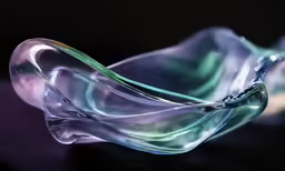 a shiny glass sculpture with swirling water inside