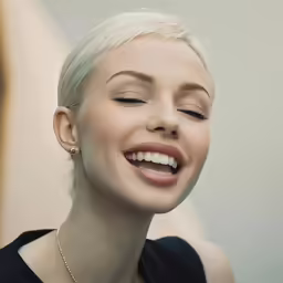 a woman is smiling and wearing a necklace