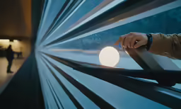 a person is holding a railing outside the window