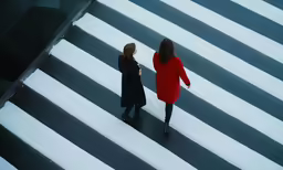 two woman standing on the outside crosswalk