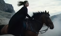 a woman on a horse wearing black clothes