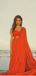 a woman in an orange gown stands on the shore