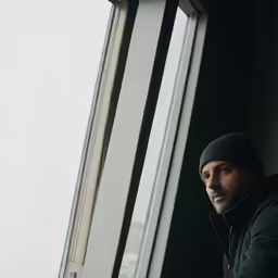 a man that is looking out a window
