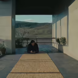 a man sitting on the ground in a long tunnel
