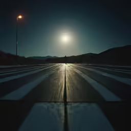 the road that appears to be covered with snow at night