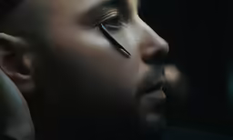 man with unique eyelashes looking intently at the camera
